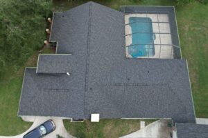 Aerial view of a house with a screened-in backyard pool.