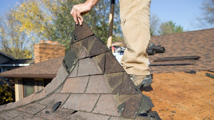  man pulling roofing off