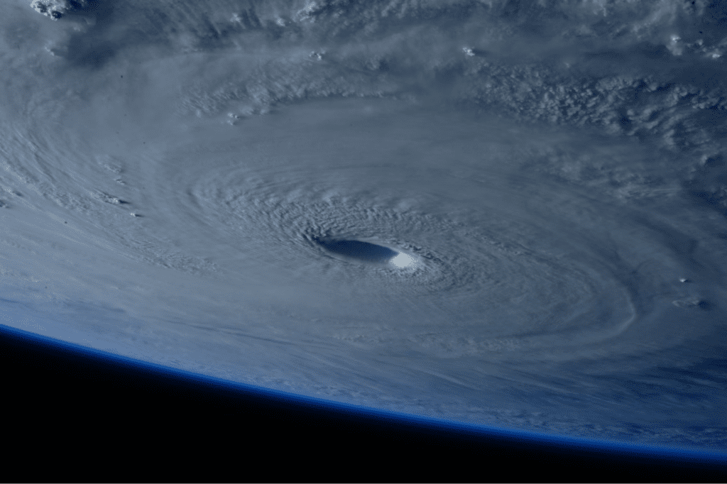 Hurricane swirling in the Atlantic Ocean, seen from space. Spiral cloud bands surround a central eye